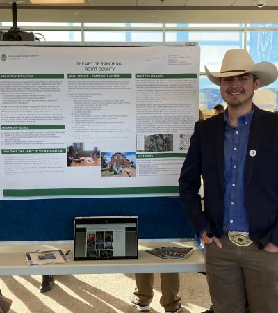 Dale Mize in his cowbow hat presenting his research at a conference.